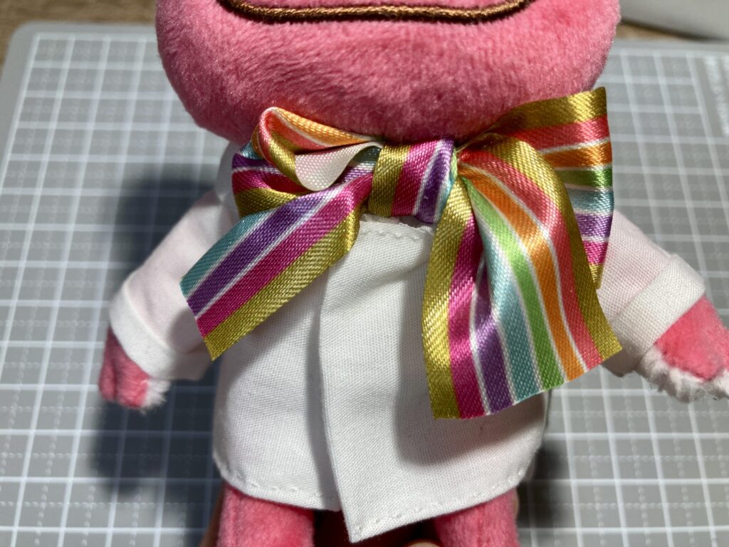 首にリボンがあるぬいぐるみが、XSサイズ・スリムのブラウスを着ている